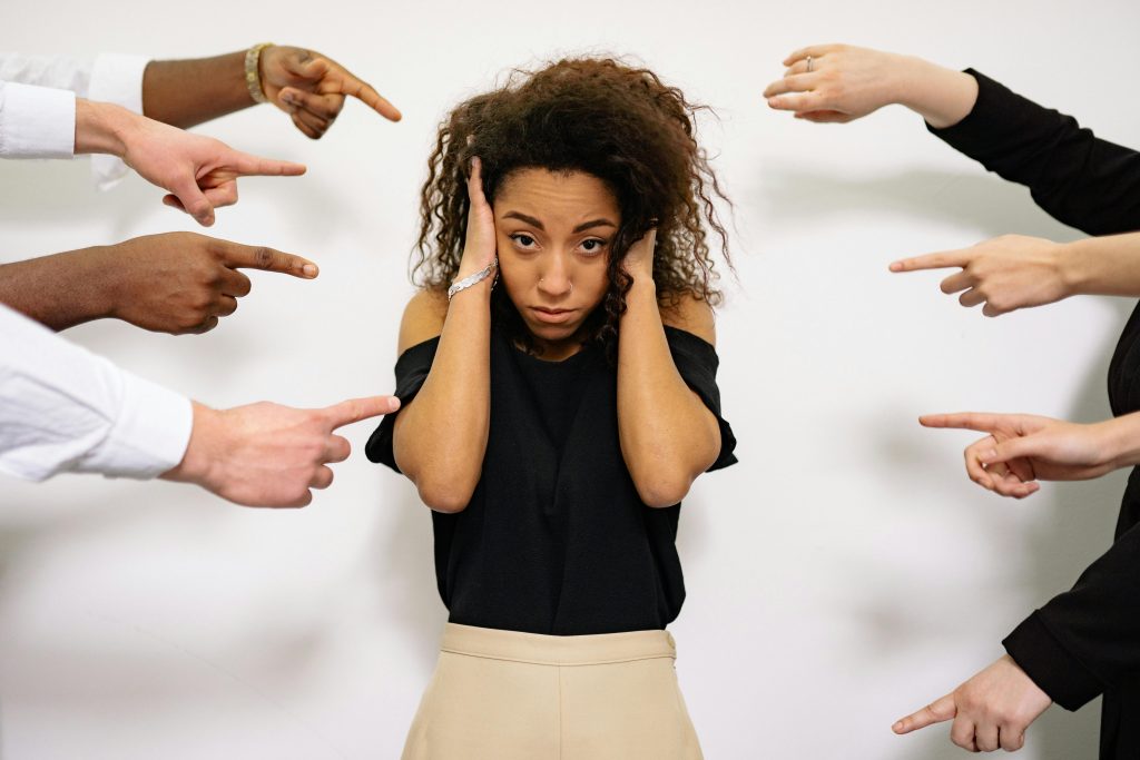 People pointing fingers at a stressed woman.