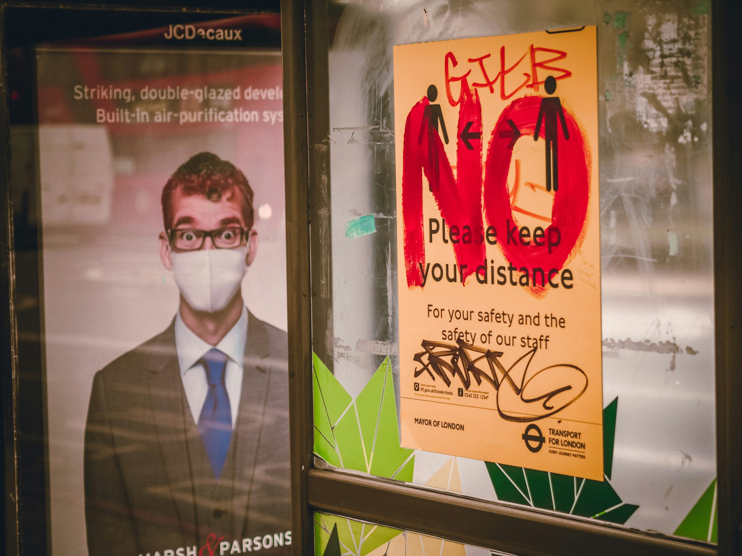 A defaced sign for physical distancing on the London during the COVID-19 pandemic.