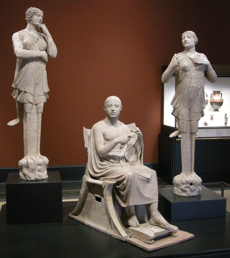 Three marble sculptures displayed in a museum setting depicting Orpheus and the Sirens.