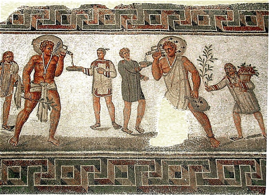 A tile mosaic image, created during the period of the Roman Empire, depicts two slaves serving wine. They each serve wine to a different non-slave male.