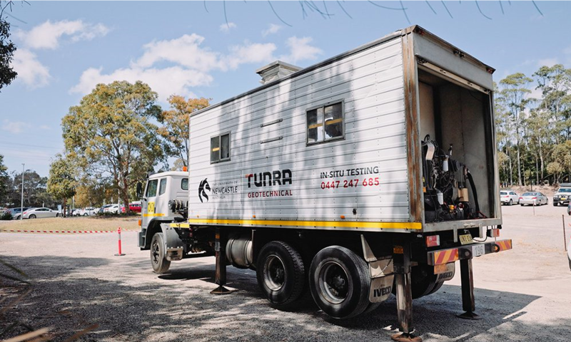 Photo of a white truck housing in situ testing equipment labelled with the University of Newcastle and TUNRA logos.