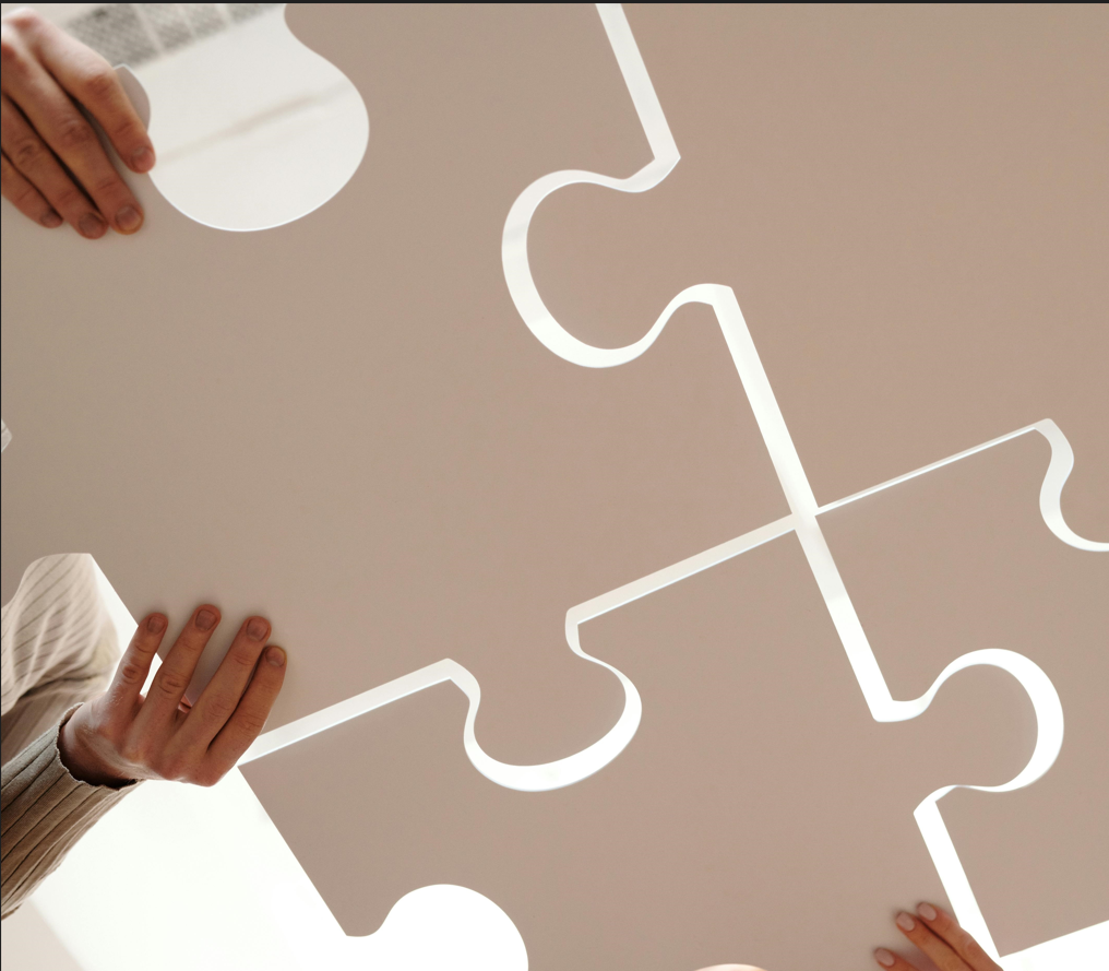human hands putting jigsaw puzzle pieces together