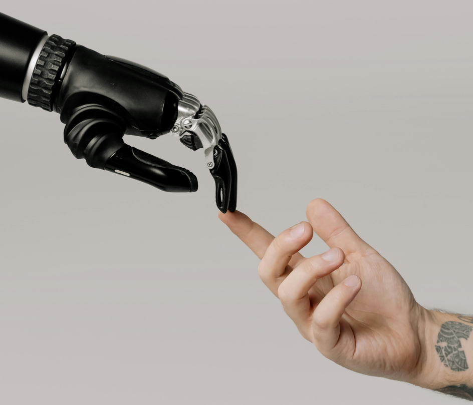 Robot finger touching human finger reminiscent of Michelangelo's Creation of Adam