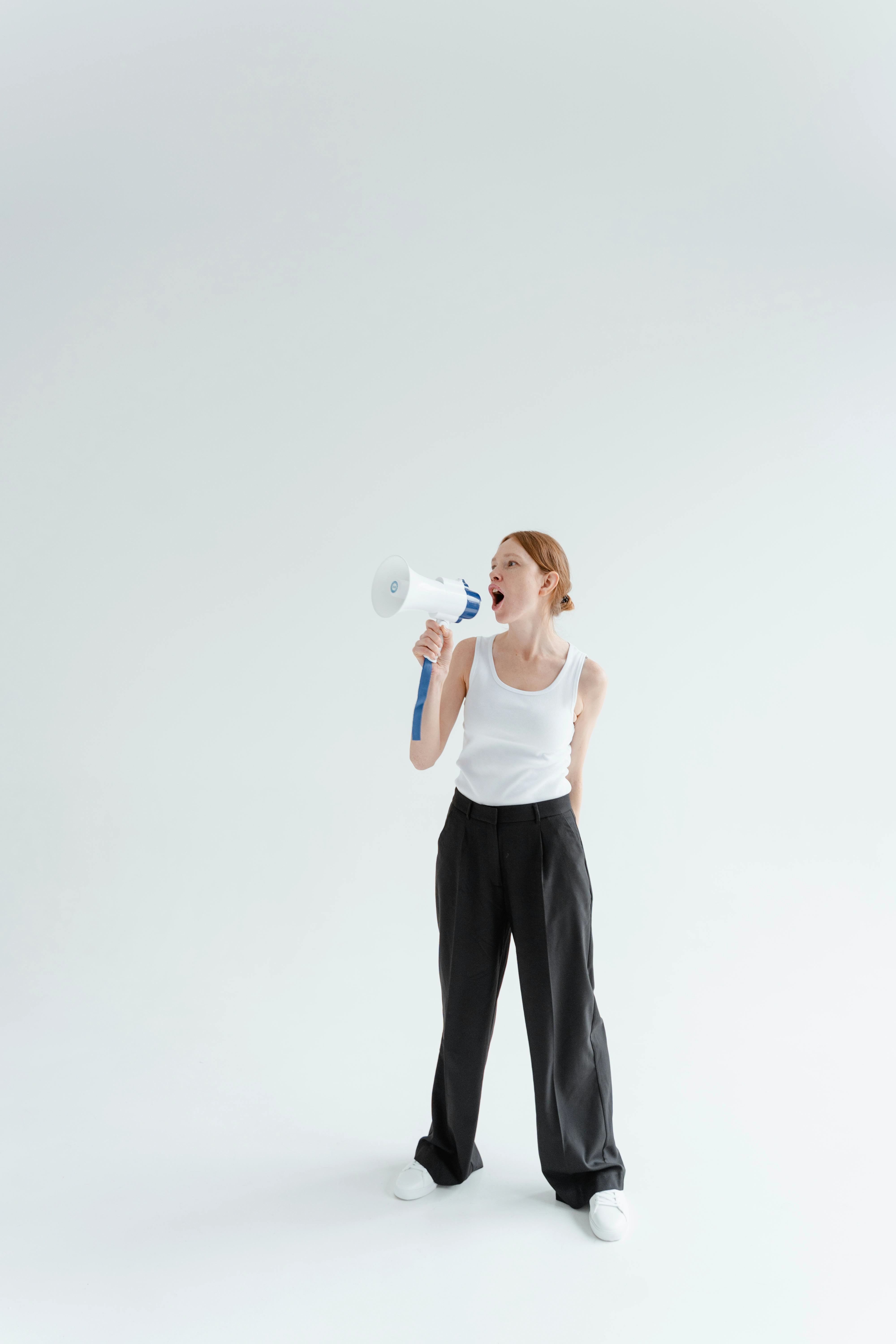 Young woman with a megaphone against a white background