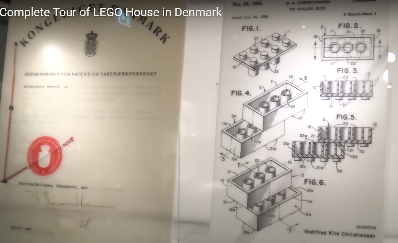Still from a video of a tour of LEGO house in Denmark featuring some patents on the wall
