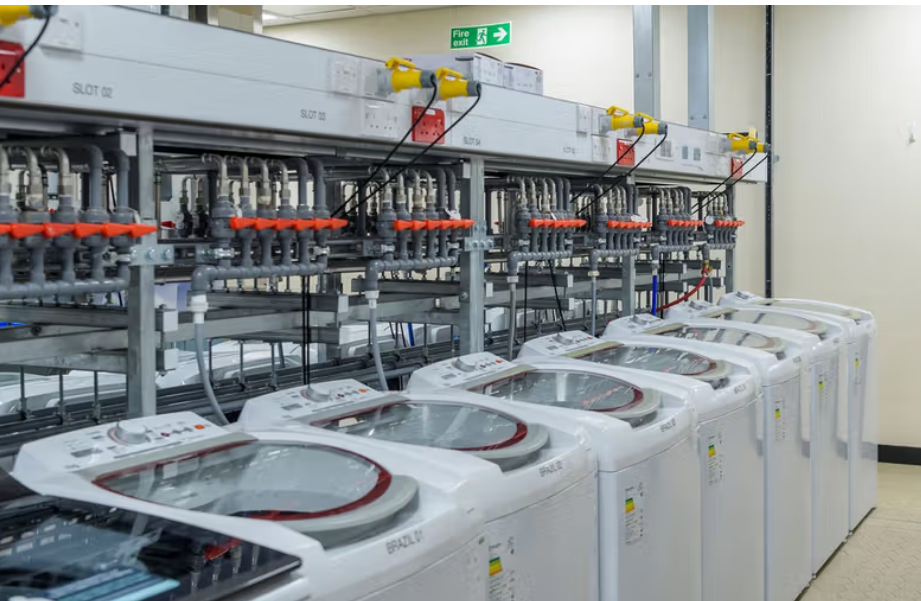 A row of washing machines hooked up to testing stations