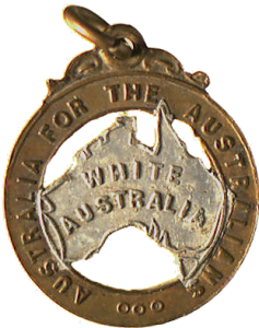 Metal badge with a map of Australia stamped with the words "White Australia", surrounded by a ring reading "Australia for the Australians".