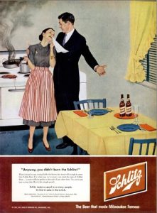 1950s women and man in kitchen with him saying at least you didn&#039;t burn the beer.