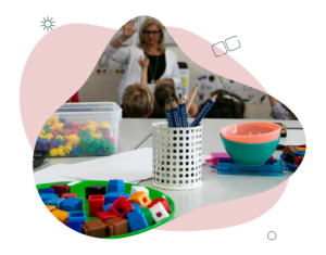 Objects on a classroom desk. There are blocks, bowls and pencils