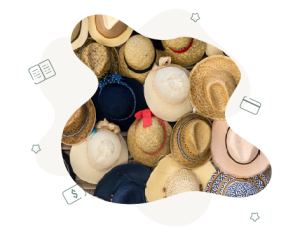 There is a lot of different straw sun hats hats placed on top of each other on the ground. This photo has been taken from a birds eye view.