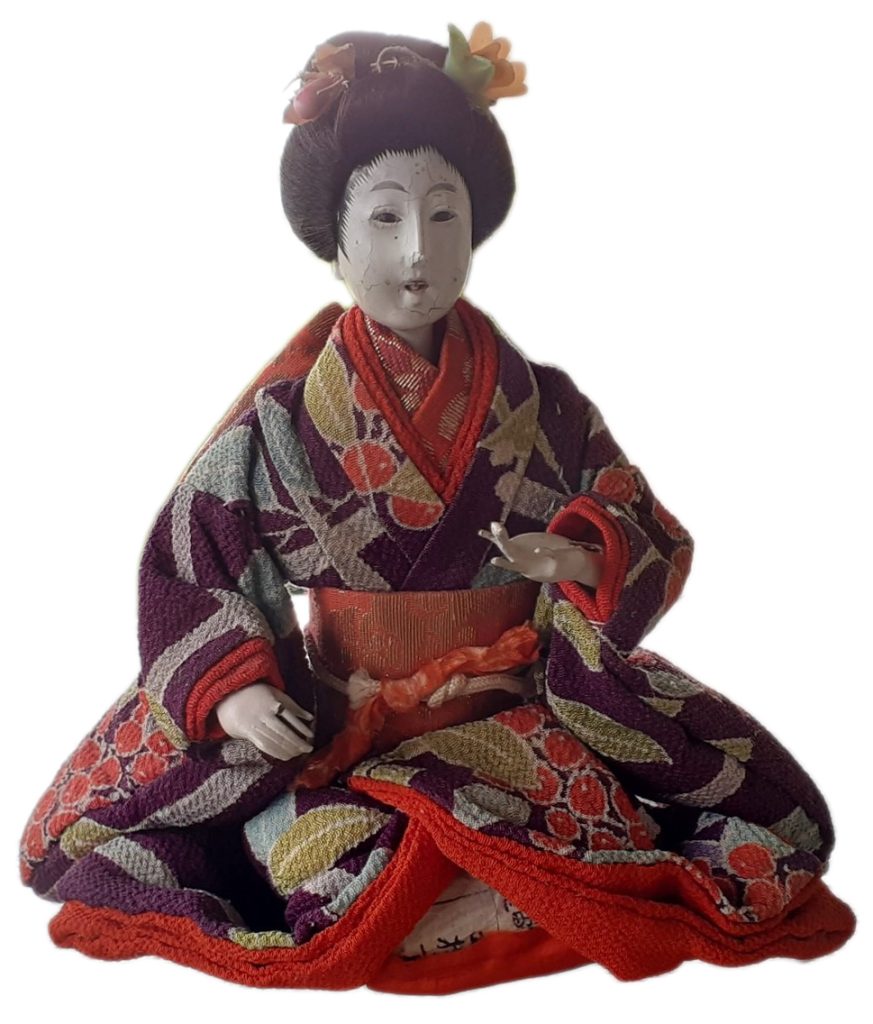 Image of Japanese doll dressed in kimono on white background.