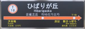 Train station signboard with place names written in both romanji and hiragana