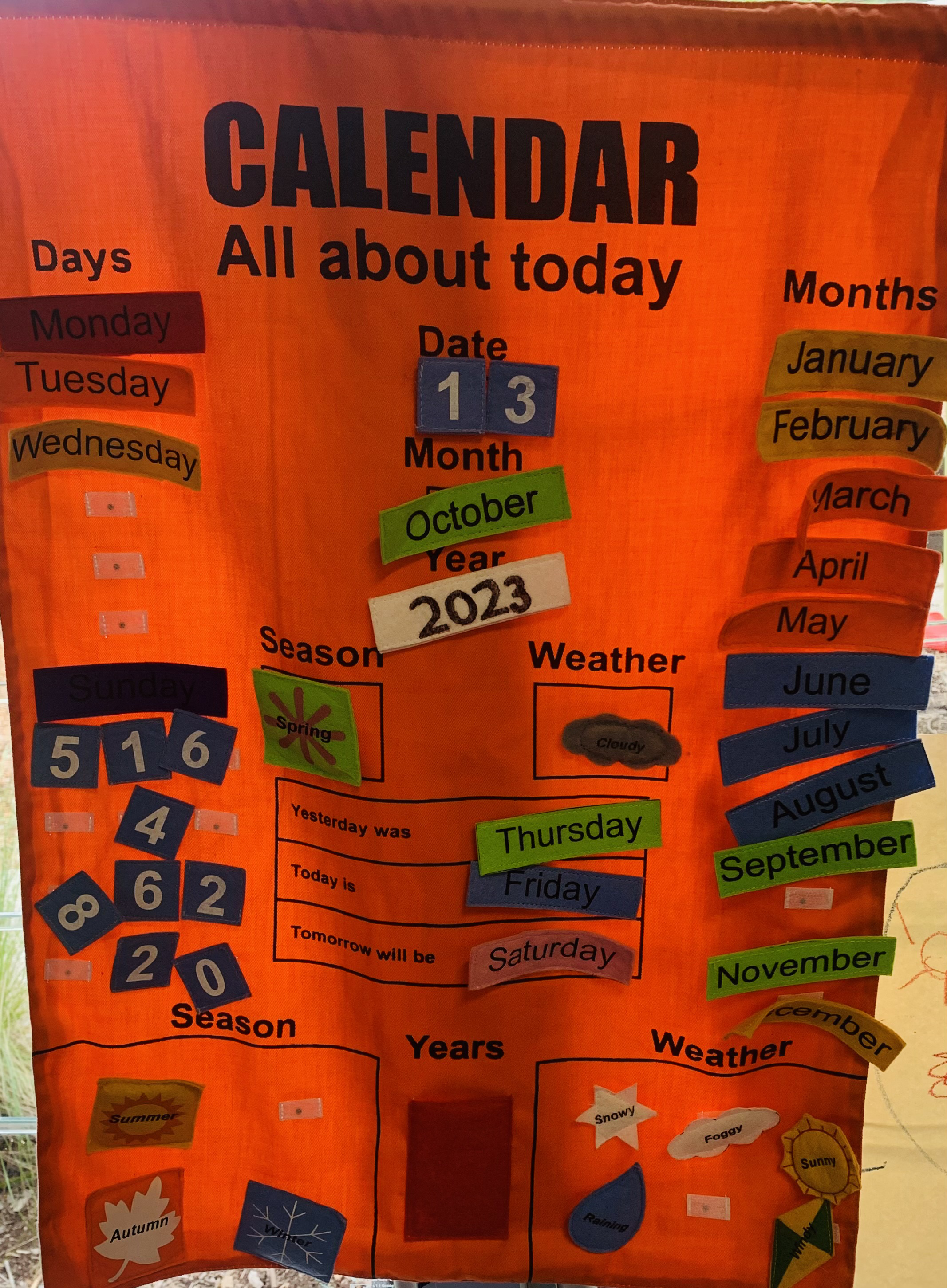hanging cloth calendar banner with moveable velcro labels to indicate day, month and year